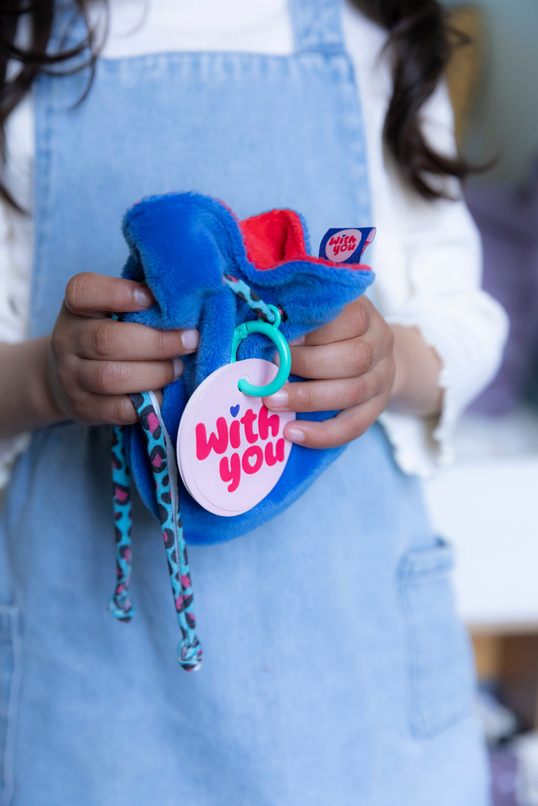 Child holding the WITH YOU Toycessory® soft plush bag