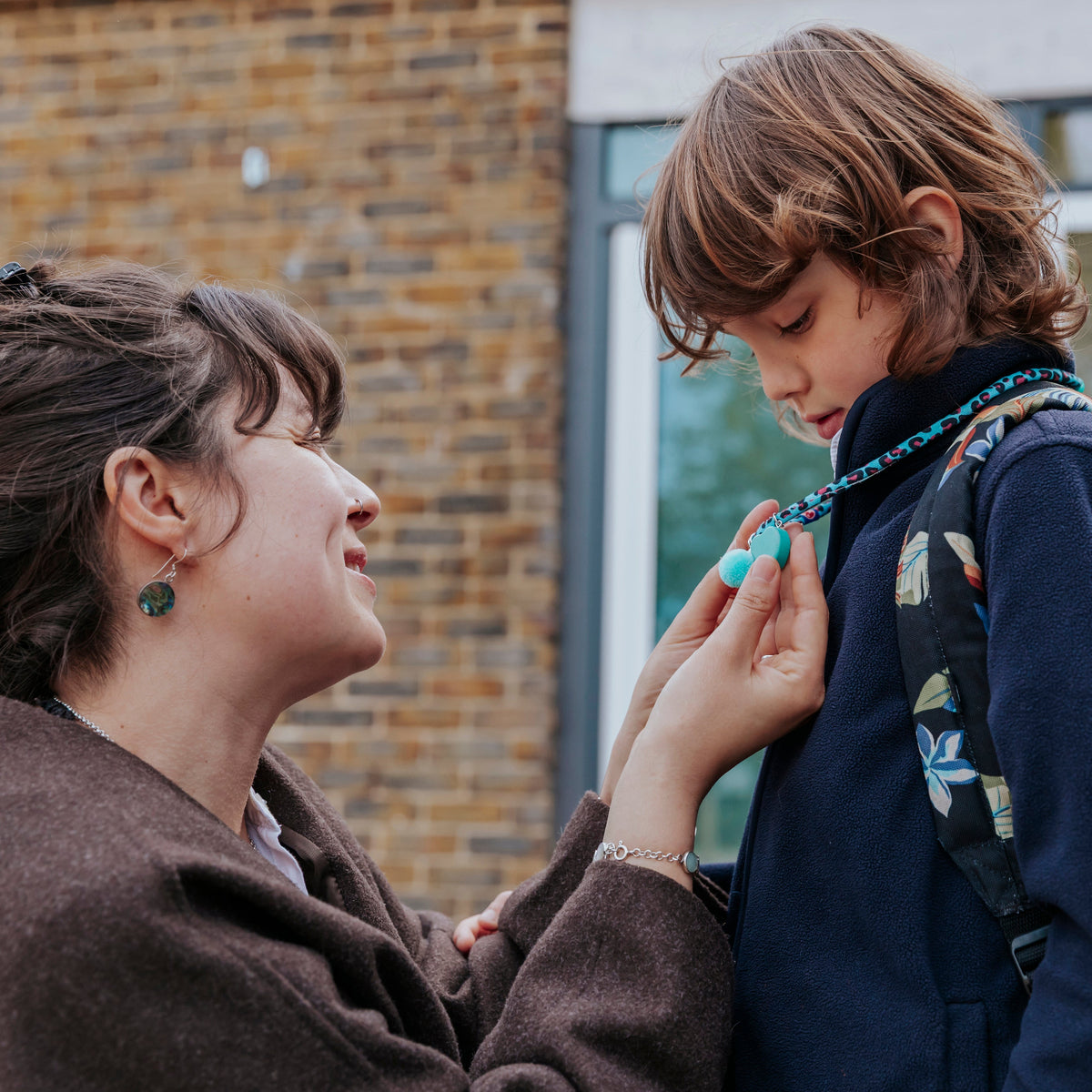 mother and child sharing a moment of connection with the WITH YOU necklace and the goodbye ritual