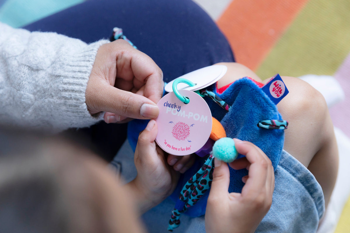 Child exploring a WITH YOU Toycessory® and the Goodbye ritual booklet